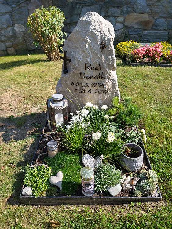 Urnengrab aus "Marquartsteiner'' Kalkstein, Schrift und Ornament aus Bronze.