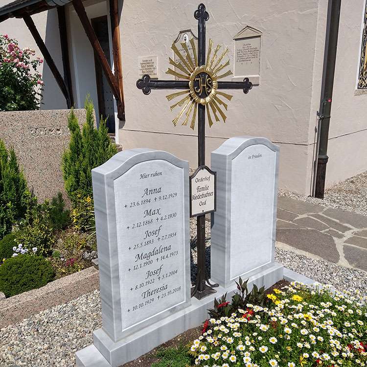 Grabanlage aus Marmor "Hell T", Schrift graviert und farbig ausgelegt.