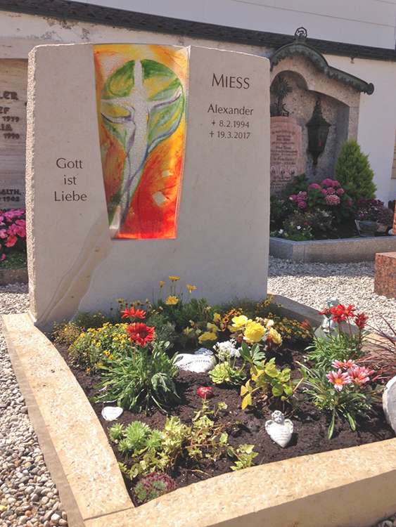 Grab aus "Jura Marmor" Kalkstein, handgefertigter Glaseinsatz, Schrift graviert und farbig ausgelegt.