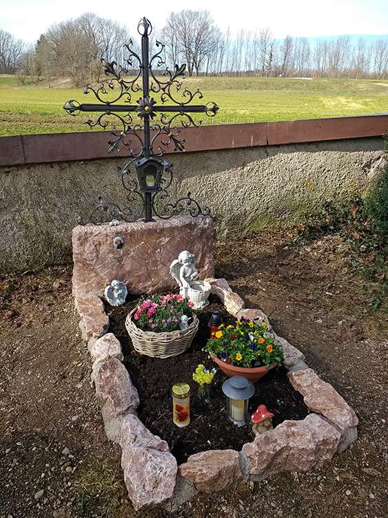 Grab aus "Ruhpoldinger Marmor" Kalkstein, renoviertes schmiedeisenes Kreuz, Schrift graviert und vergoldet.